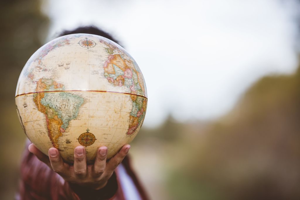 Closeup shot of a person holding a globe with a blurred background